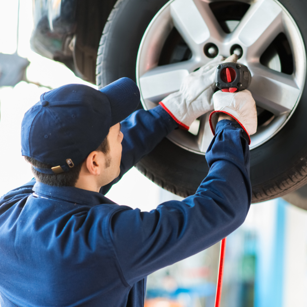 Mechanician changing car wheel in auto repair shop