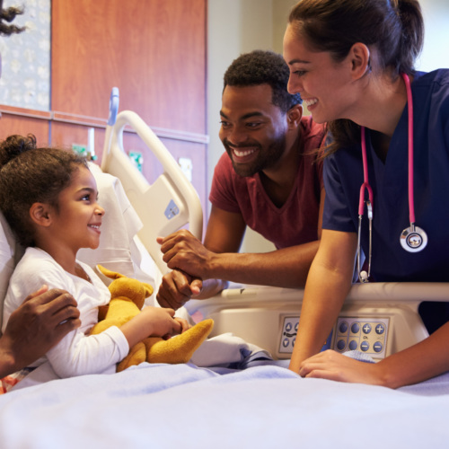 Pediatrician Visiting Parents And Child In Hospital Bed
