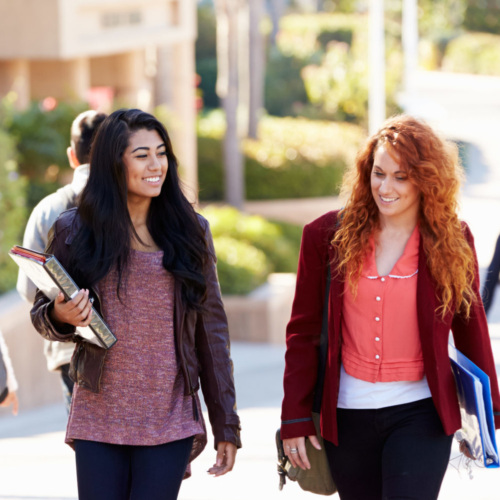 Female Students Walking Outdoors On University Campus