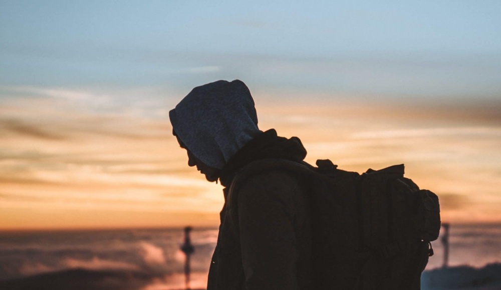 Young man silhouetted by the sunset.