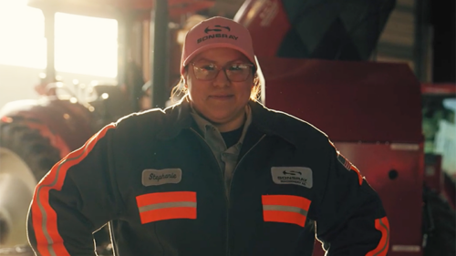 A woman standing in front of a tractor.