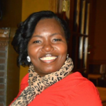A woman wearing a red top and leopard print scarf smiles at the camera indoors.