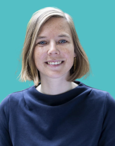 A woman with short, light brown hair and a navy blue top smiles at the camera against a solid teal background.